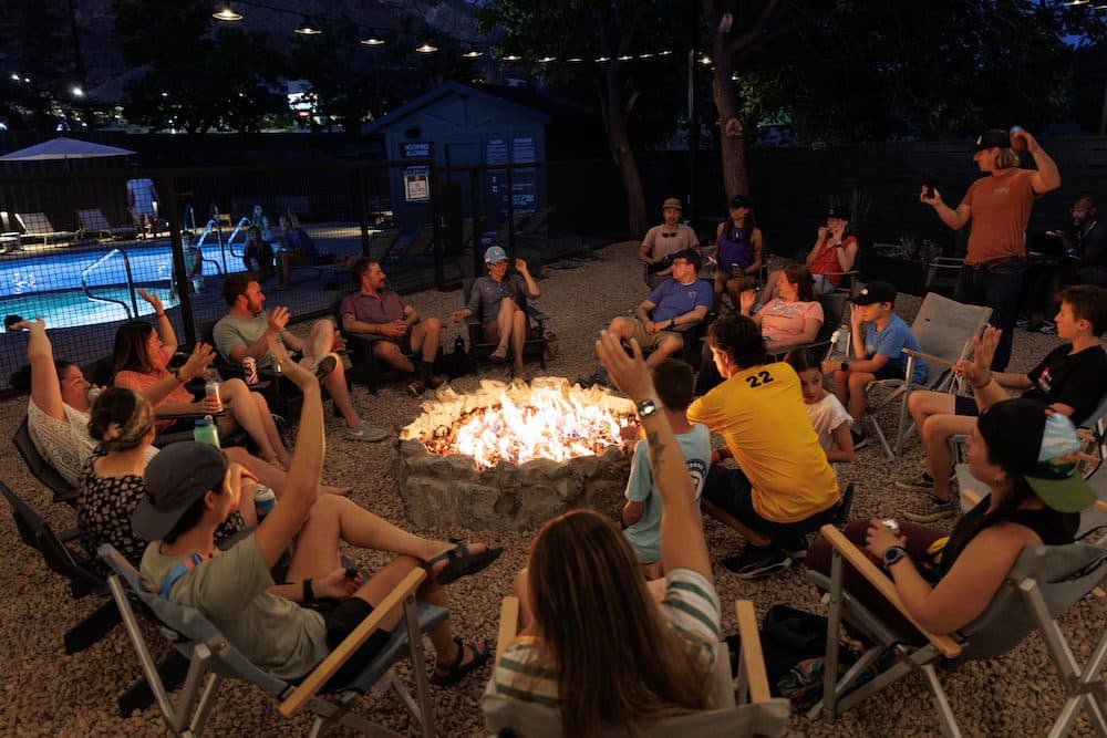 large group of people sitting by campfire