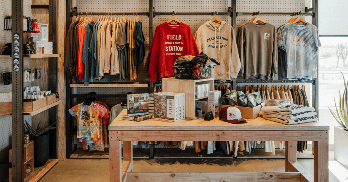 A shop display wooden shelves containing clothing, books and other accessories.